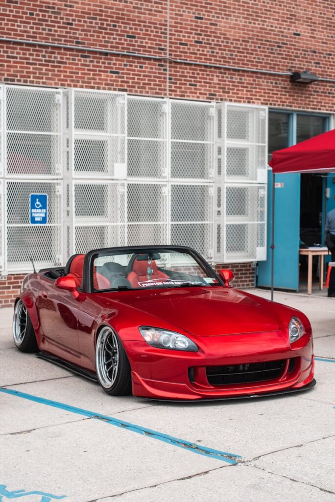 red convertible coupe on gray pathway